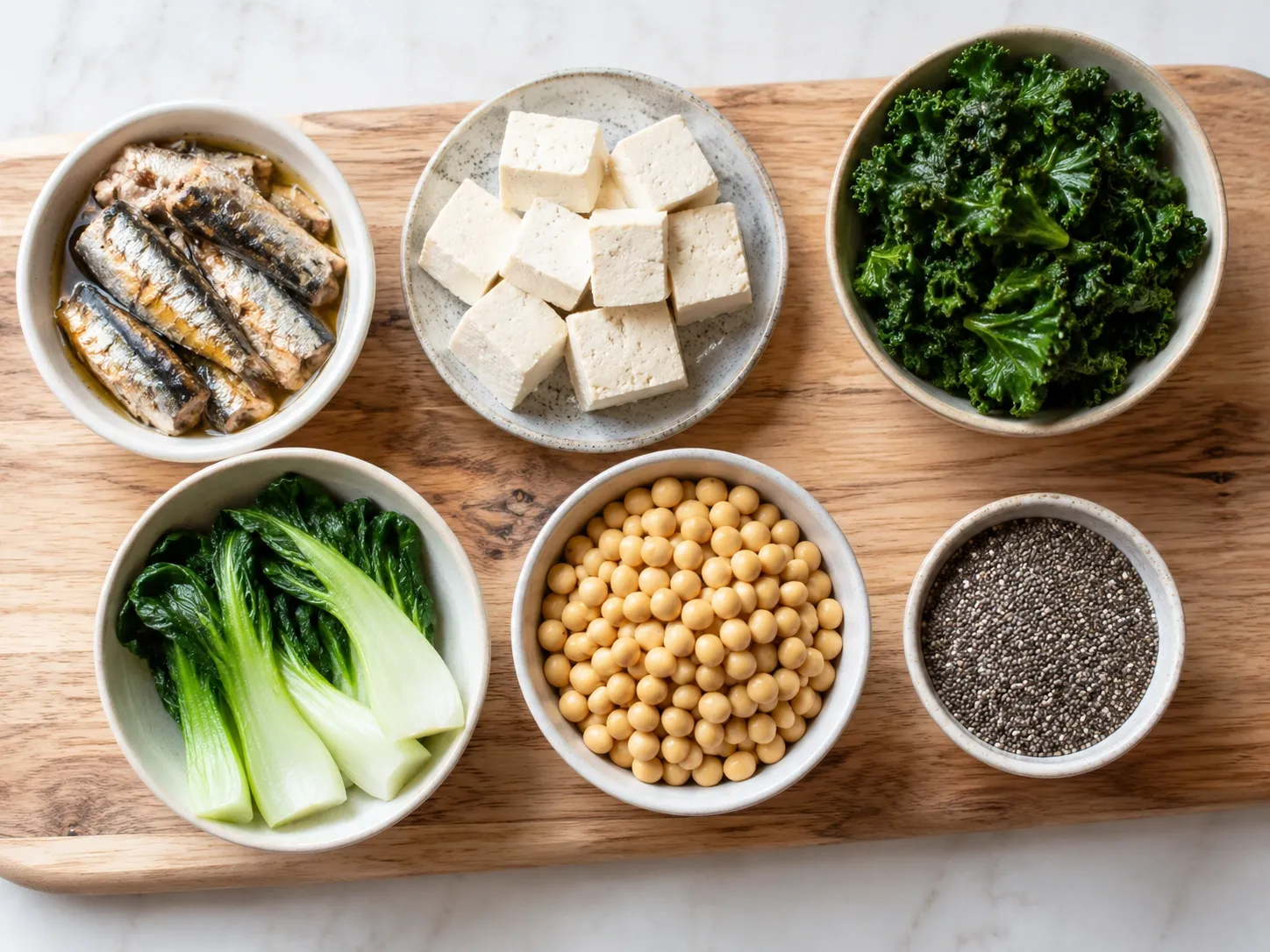 Diferentes fontes de cálcio sem leite, incluindo sardinhas, tofu, couve, bok choy, soja e chia.